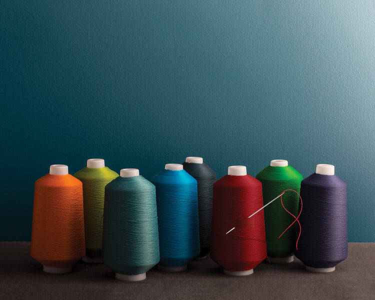 Multicoloured sewing spools reflect the accentuated response to light found in Aura® Colour Stories®.